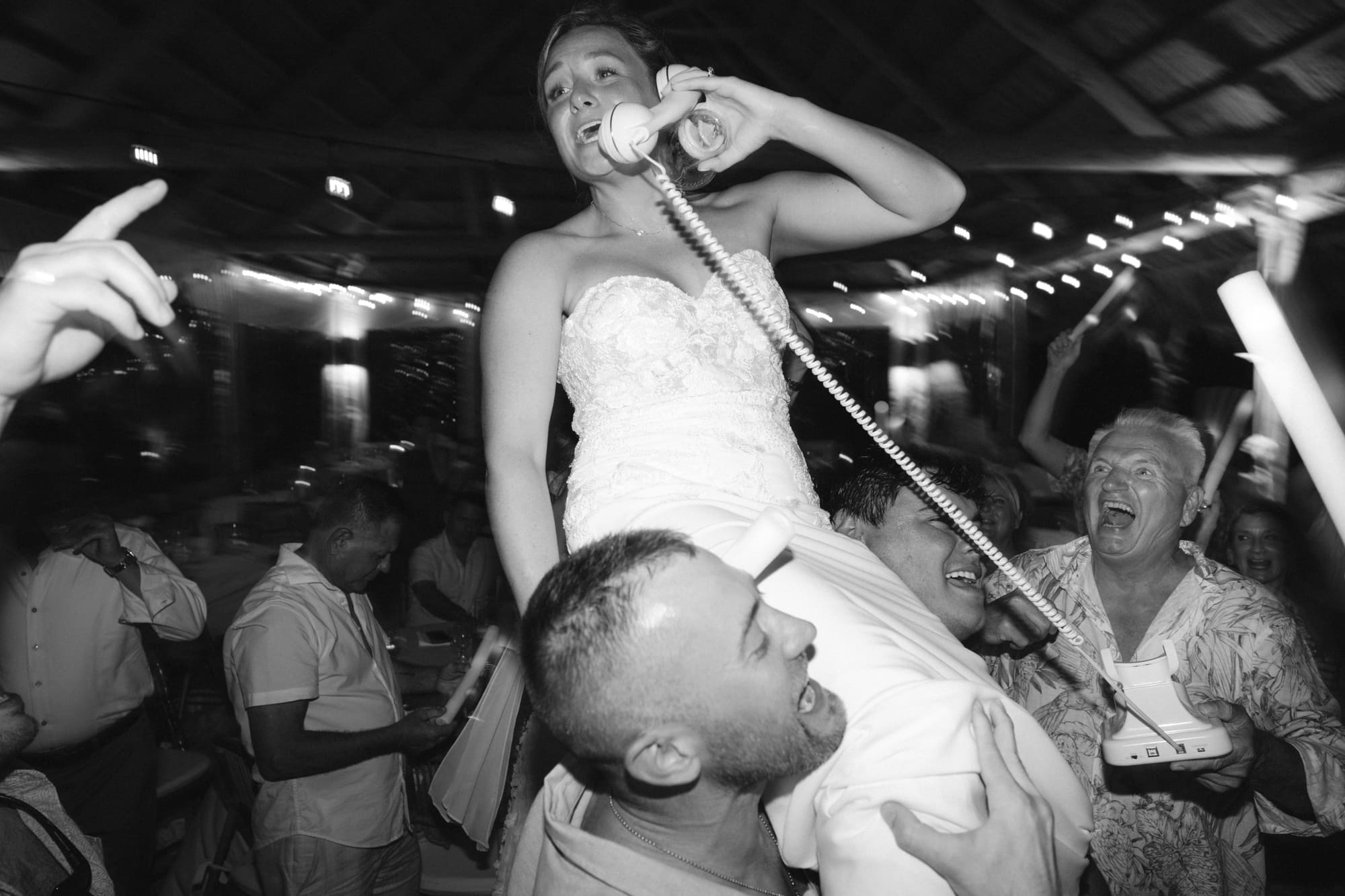 Bride celebrated by wedding guests on the dance floor
